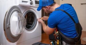 Technician inspecting a washing machine at home in Dubai, checking issues and estimating repair cost