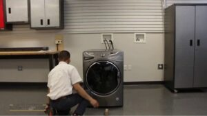 Homeowner safely inspecting and disconnecting a washing machine in a bright, clean laundry room before performing maintenance.