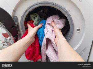 Front-load washing machine with standing water in the drum in a clean home laundry room.
